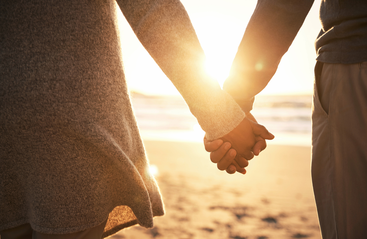 Rearview shot of an unrecognizable couple holding hands while at the beach
